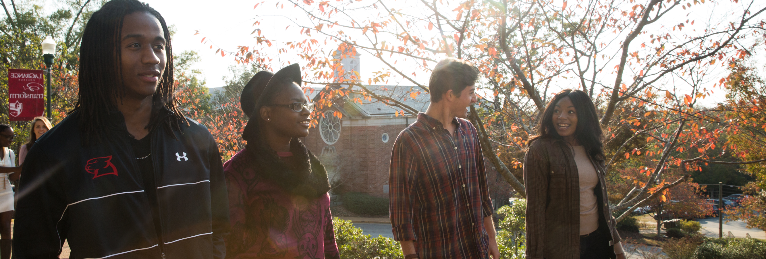 Students walk along a cobblestone path with the College chapel in the background